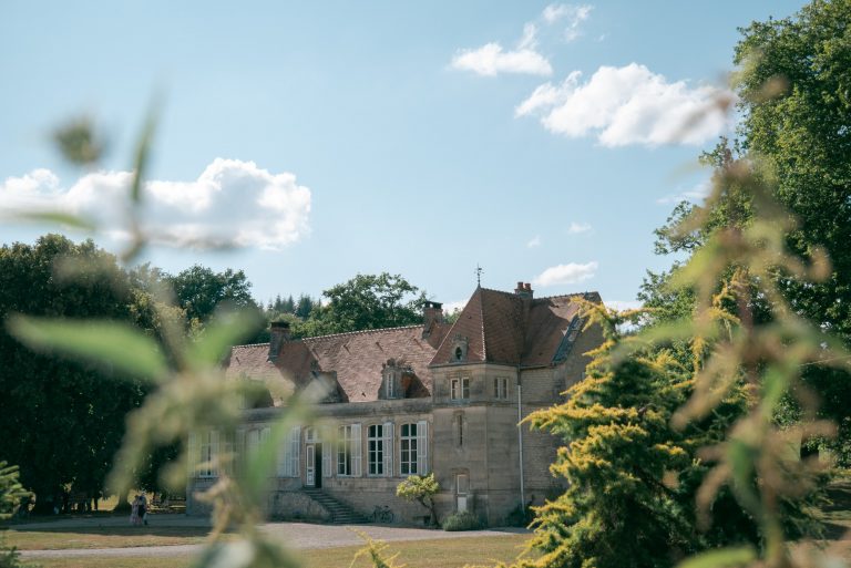 Large listed stone country house in Oxfordshire, seen through trees