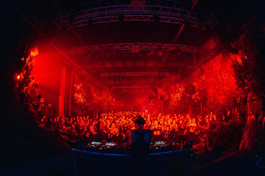 Crowd dancing under red lights at SWG3 in Glasgow, the venue heated and cooled by BODYHEAT